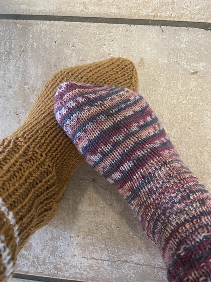 två stickade sockar i olika färger