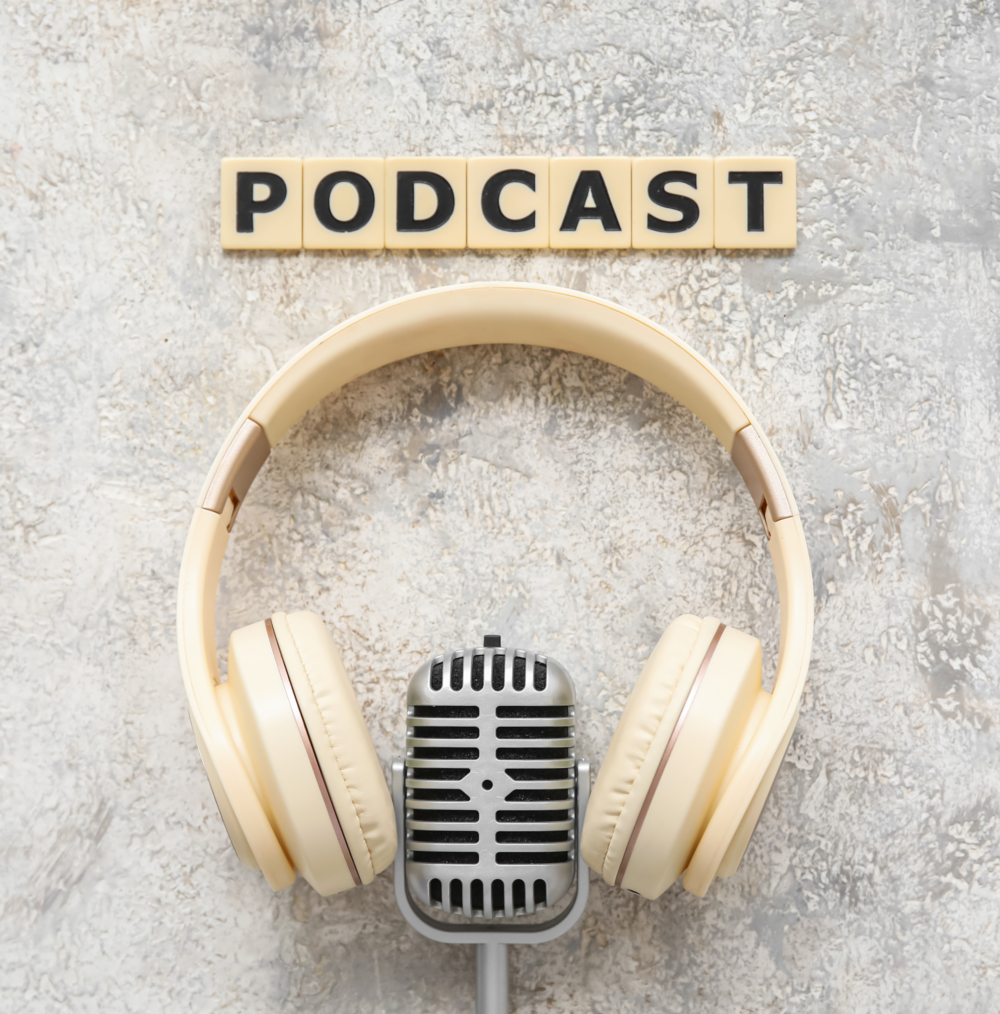 Ett par hörlurar och en mikrofon ligger under ordet 'PODCAST' på en ljus bakgrund.
