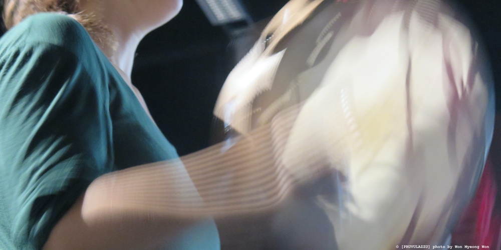 Närbild av en person i grön tröja som rör på armarna, bilden är suddig av rörelse.