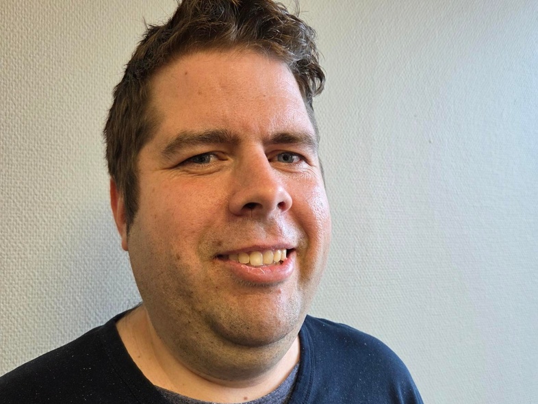 Person med mörkt hår står mot en ljus vägg, ansiktet är suddat för anonymitet.