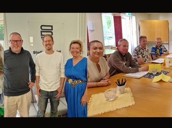 Tre bilder i en: personer lagar mat, poserar framför en skylt och sitter i möte runt ett bord.