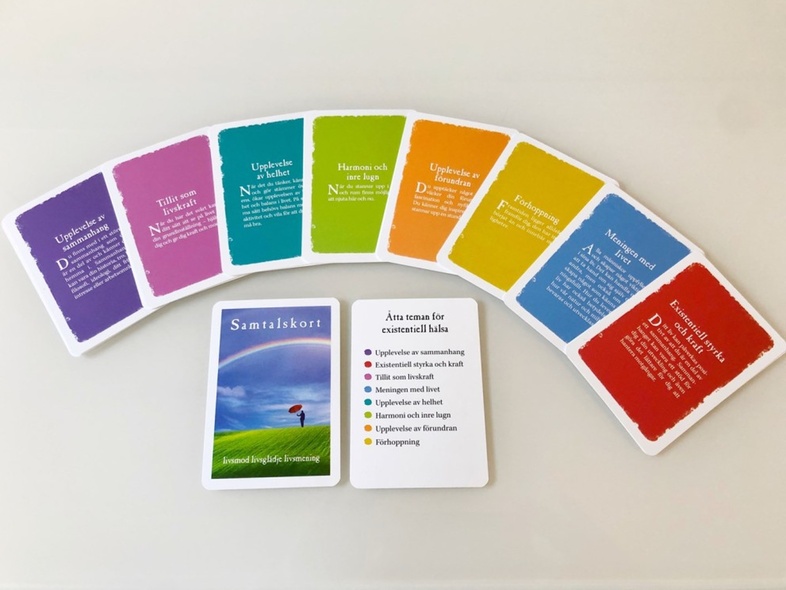 Flera färgglada samtalskort ligger utspridda på ett bord, med en instruktion i mitten.