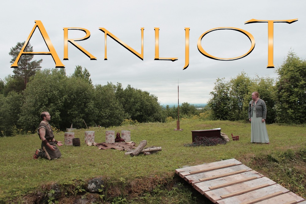Två personer i historiska kläder står på en gräsmatta med texten 'Arnljot' ovanför dem.
