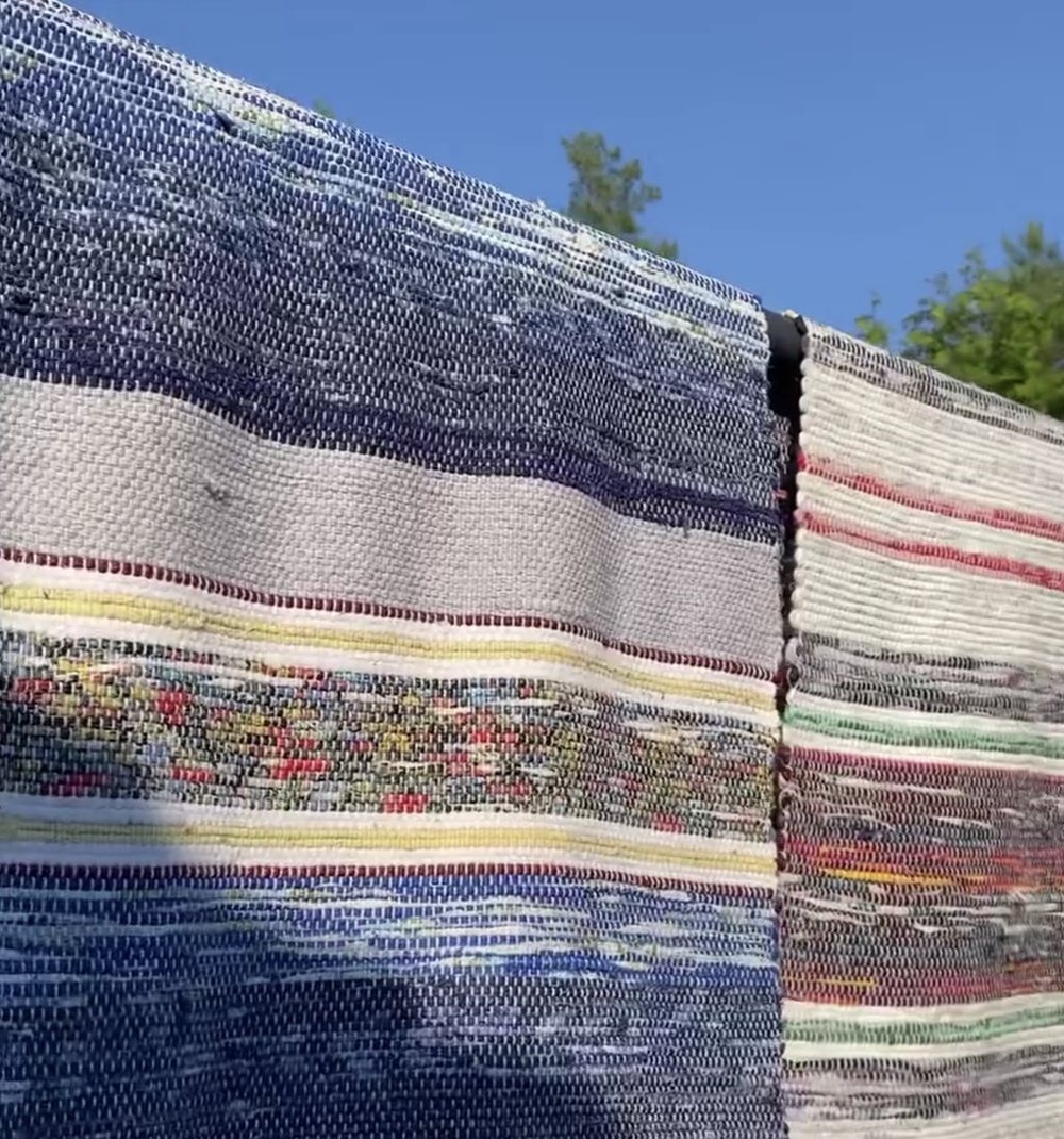 Färgglada trasmattor hänger på tork utomhus