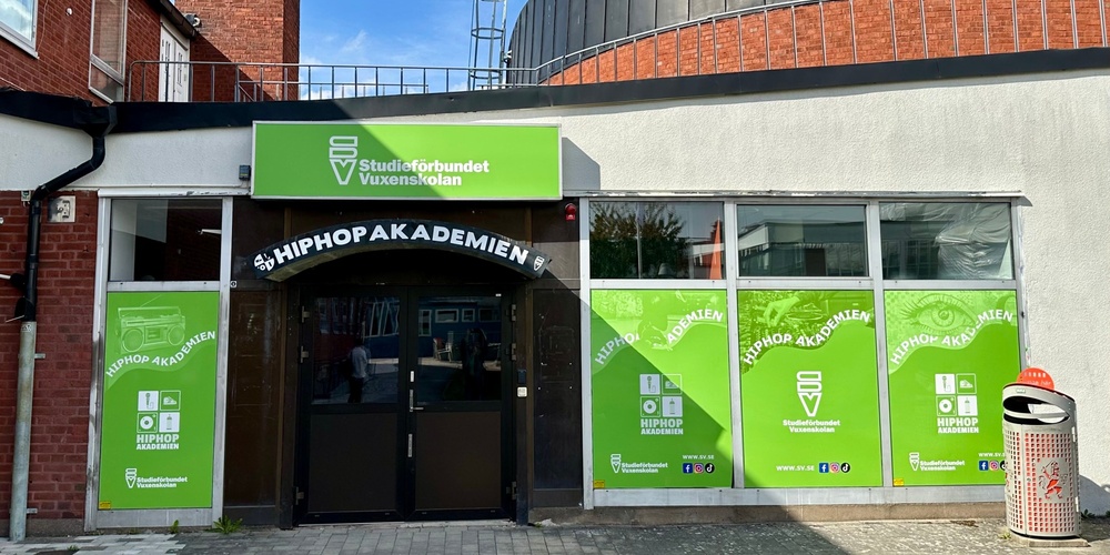 Hus med två dörrar och grön skyltning 