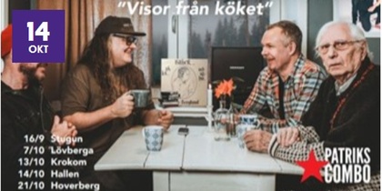 Fyra personer sitter runt ett köksbord och samtalar, med kaffekoppar och blommor på bordet.