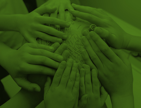 Flera händer läggs tillsammans på en yta, bilden har ett grönt filter.