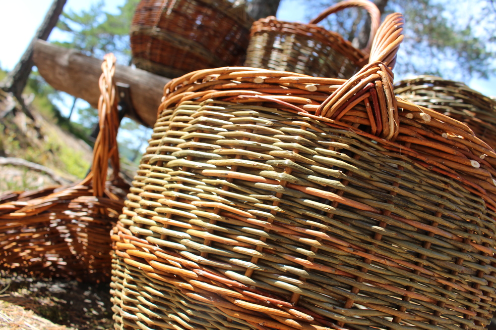 Närbild på flera flätade korgar av naturmaterial utomhus i solljus.