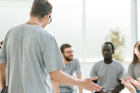 En grupp människor sitter i en cirkel och samtalar i ett ljust rum.