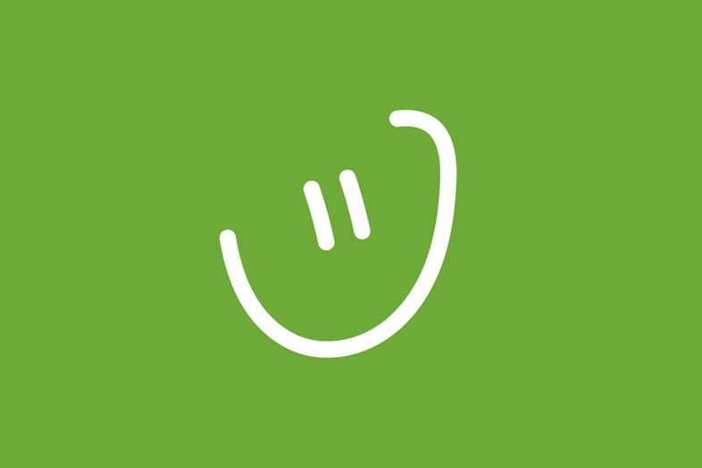 En enkel, vit, tecknad smiley på grön bakgrund.