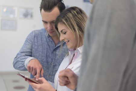 Två personer tittar och pekar på en surfplatta tillsammans, båda ser glada ut.