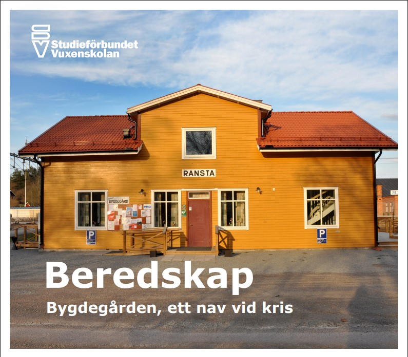 Gul bygdgårdsbyggnad med rött tak och skylten 'RANSTA', text om beredskap och krisnav.