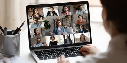 Person deltar i ett videomöte på en bärbar dator med flera deltagare synliga på skärmen.
