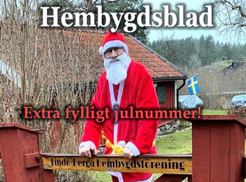 Person utklädd till jultomte står vid en röd grind framför en landsbygdsmiljö med svensk flagga.