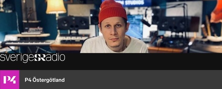 Man med röd mössa sitter i en musikstudio med ljudutrustning i bakgrunden.