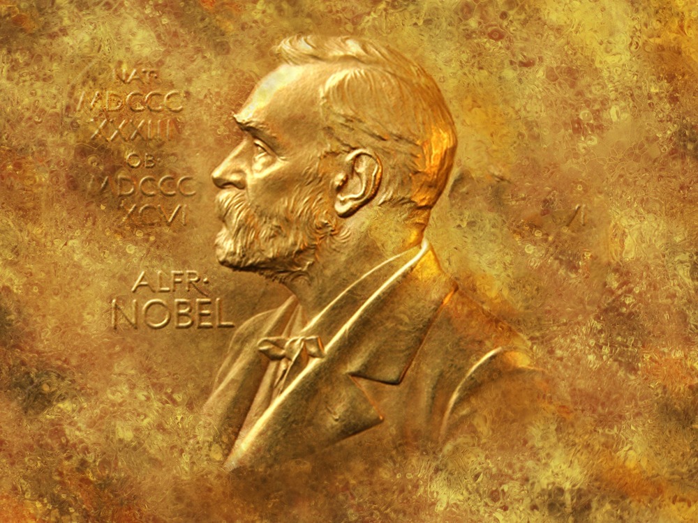 Ett guldmynt med en relief av en person i profil och texten 'ALFR. NOBEL'.