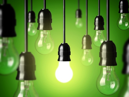 Flera hängande glödlampor mot grön bakgrund, en lampa lyser medan resten är släckta.