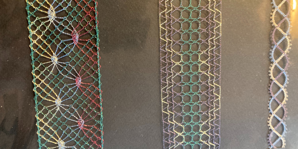 Tre färgglada spetsband med olika mönster ligger på en svart bakgrund.