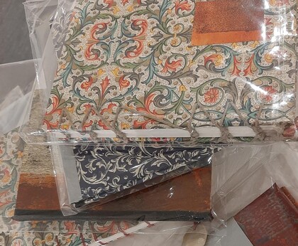 Handbundna anteckningsböcker med färgglada, mönstrade omslag i plastförpackning.