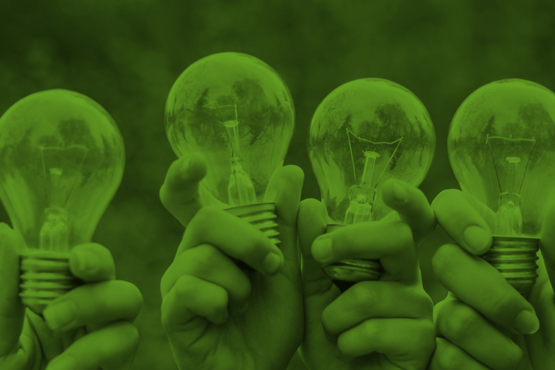 Fyra händer håller upp varsin glödlampa mot en suddig grön bakgrund.