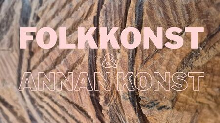Texten 'FOLKKONST &amp; ANNAN KONST' i rosa på en bakgrund av snidat trä.