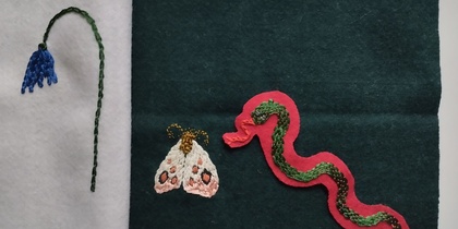 Broderade motiv på tyg: en blå blomma, en fjäril och en orm på olika färgade bakgrunder.