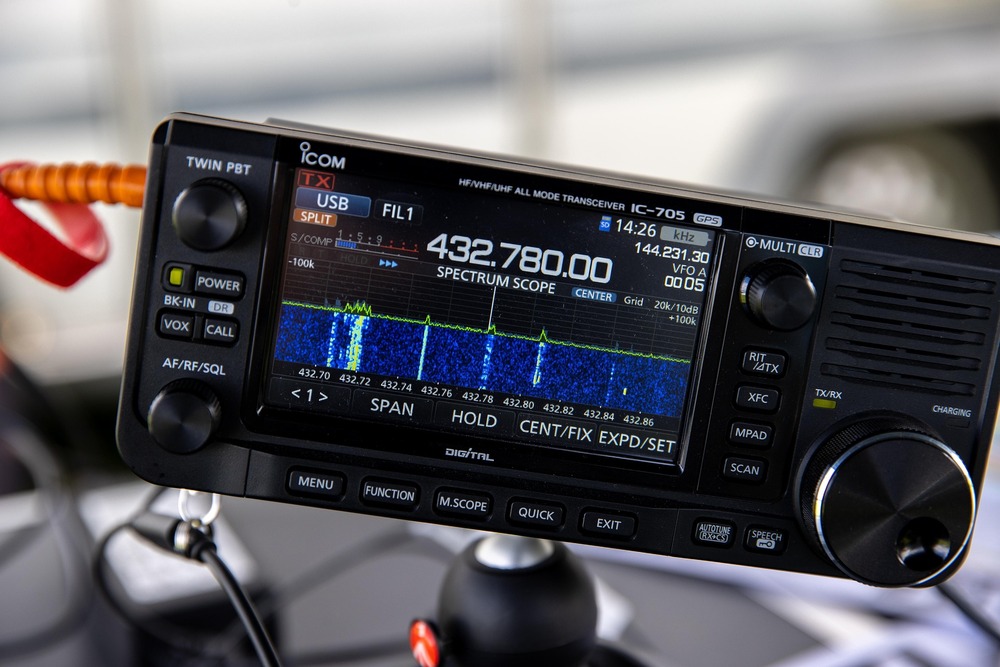 Närbild på en Icom IC-705 amatörradio med färgskärm som visar frekvens och spektrumanalys.