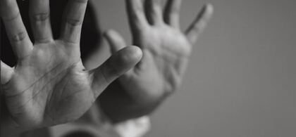 Två uppsträckta händer i förgrunden, suddig bakgrund, svartvit bild.