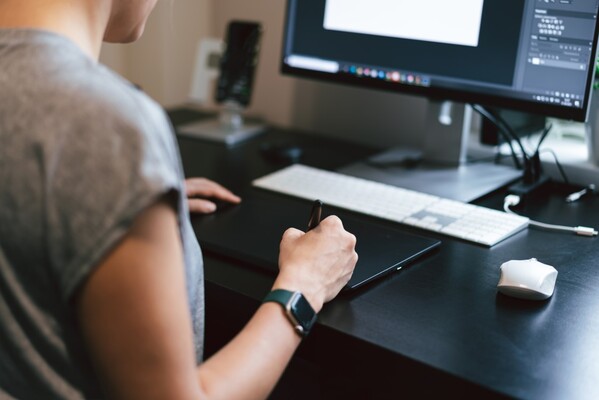 Person sitter framför en dator och arbetar.