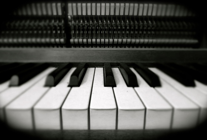 Närbild av pianotangenter i svartvitt, med fokus på de vita och svarta tangenterna.