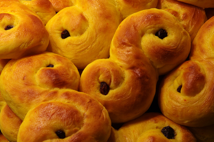 Närbild på flera lussekatter, saffransbullar med russin, staplade tillsammans.