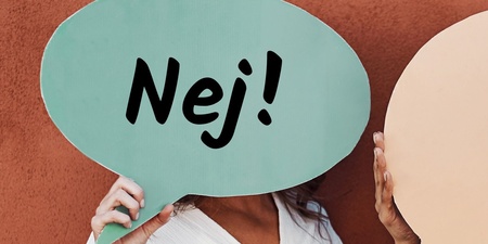 Person håller upp en grön pratbubbla med texten 'Nej!' framför ansiktet.