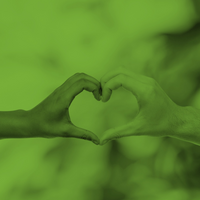 Två händer formar ett hjärta mot en suddig bakgrund, bilden har ett grönt filter.