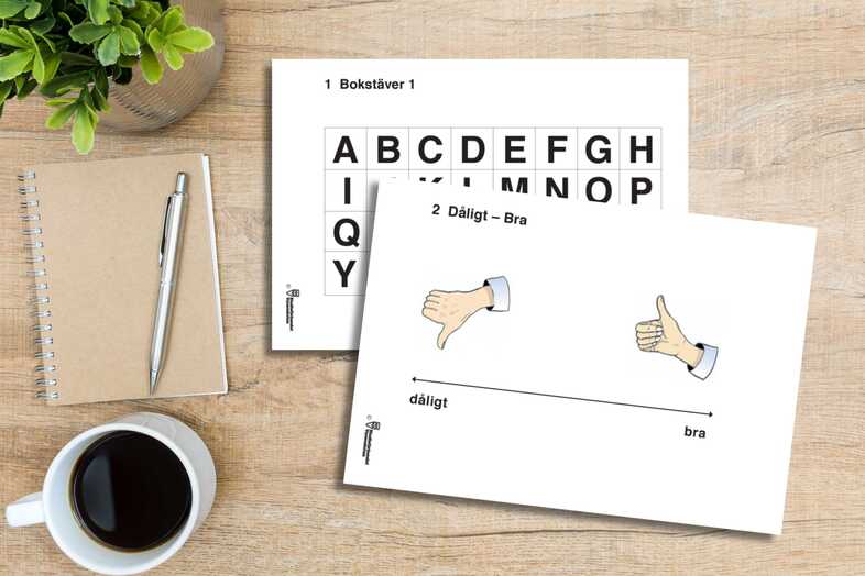 Två talstödsskyltar ligger på ett bord tillsammans med en kopp kaffe, en beige anteckningsbok och en penna.