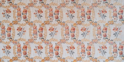 Blommigt mönster på tapet i ljusa färger med inslag av orange, gult och blått.