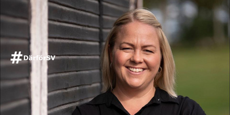 Leende kvinna med blont hår står utomhus vid en svart trävägg. Texten '#DärförSV' syns till vänster.