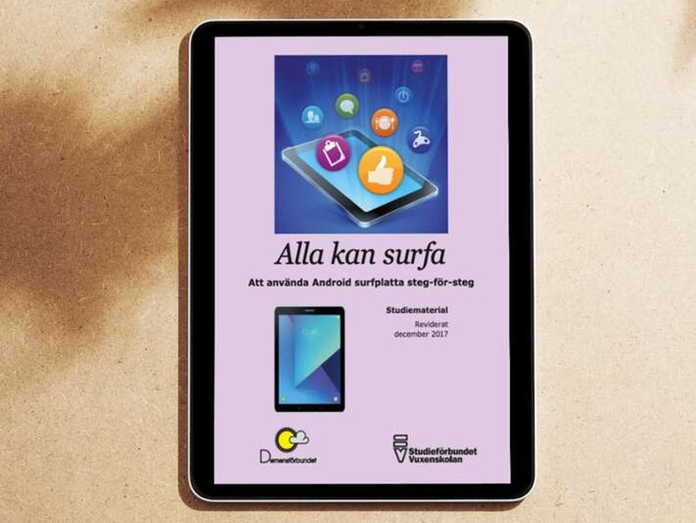 En surfplatta på ett sandfärgat underlag visar en svensk guide om att använda Android surfplatta.