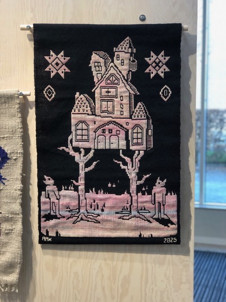 Vävd textil med motiv av ett sagohus på två träd, omgivna av geometriska mönster och figurer, i rosa och svart.