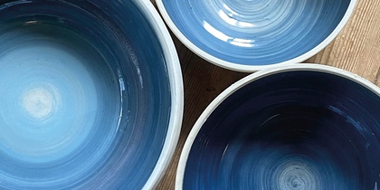 Tre blå keramikskålar på ett trägolv med texten 'Prova på: Keramik' i hörnet.