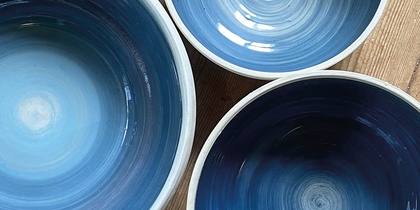 Tre blå keramikskålar på ett trägolv med texten 'Prova på: Keramik' i hörnet.