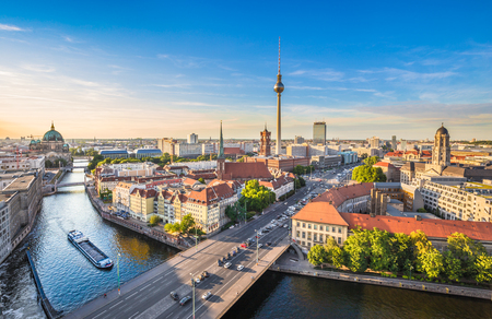 Vy över Berlin med floden Spree, TV-tornet och historiska byggnader under en klar blå himmel.