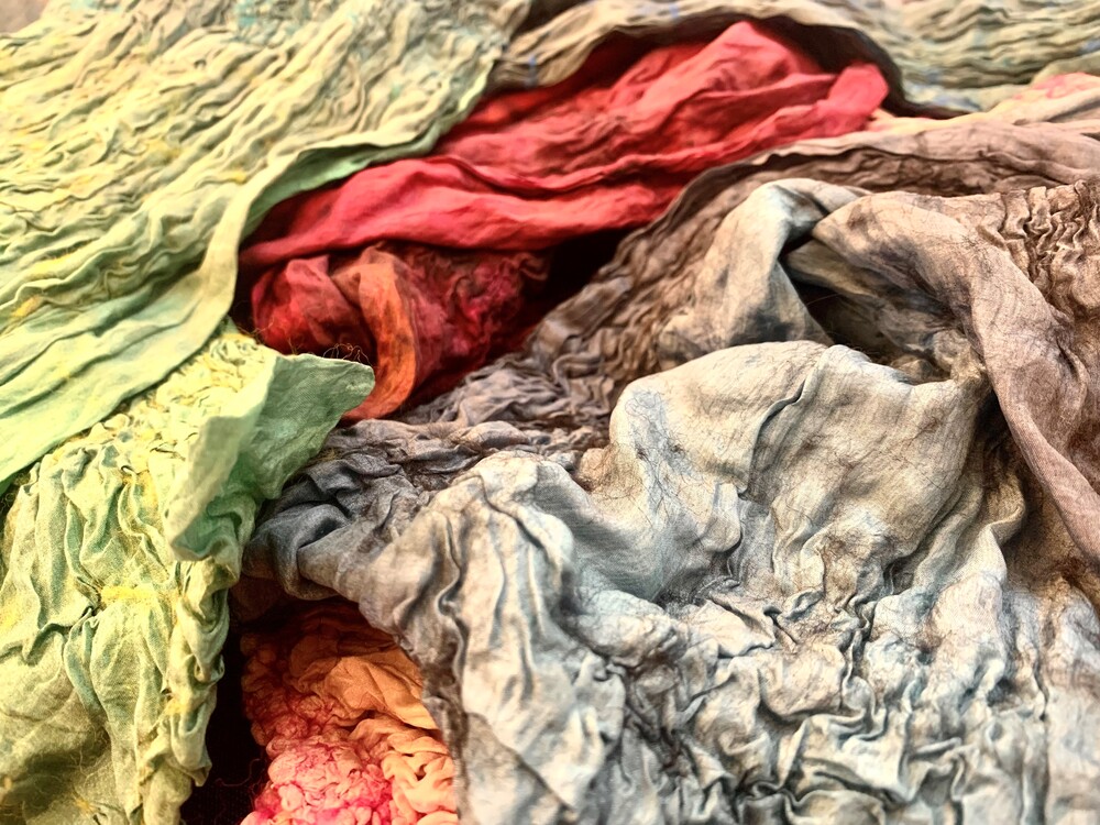 Närbild av skrynkliga tyger i olika färger, inklusive grönt, rött och blått.