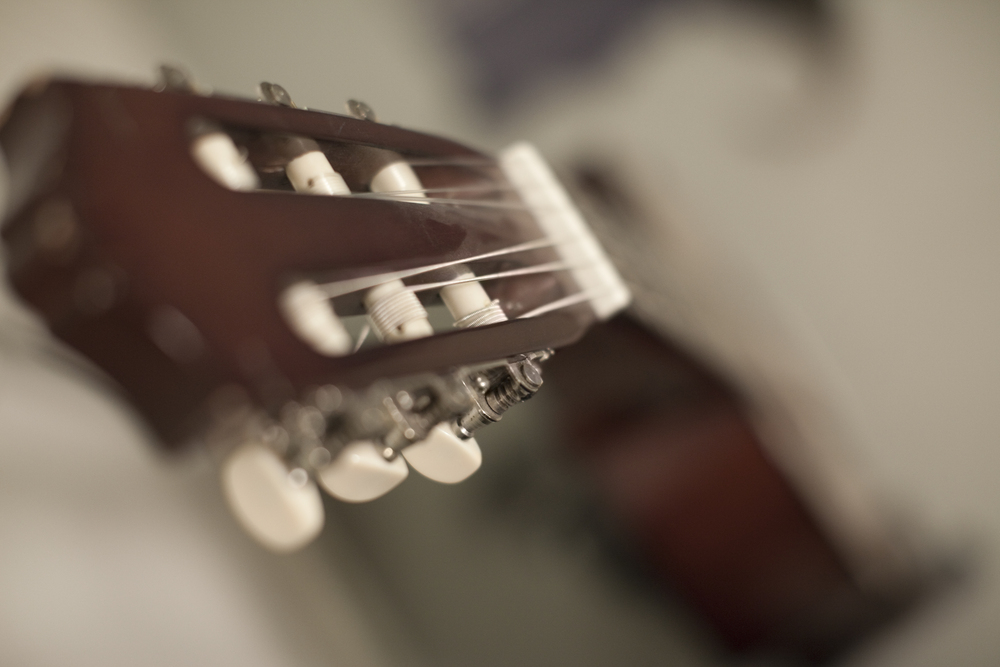 Närbild av huvudet på en klassisk gitarr med fokus på stämskruvarna.