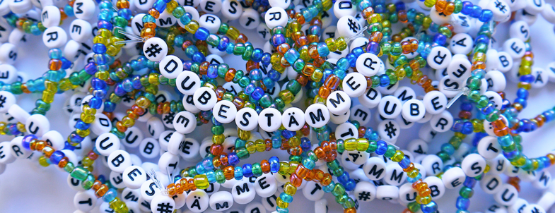 Flera färgglada armband med bokstavspärlor som bildar texten #DUBESTÄMMER.