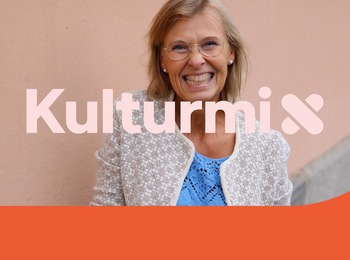 Leende kvinna med glasögon står mot en ljus vägg, texten 'Kulturmix' syns över bilden.