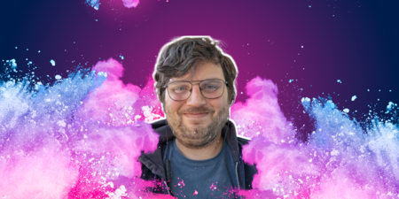 Leende man med glasögon framför färgstark bakgrund med rosa och blått pulver.