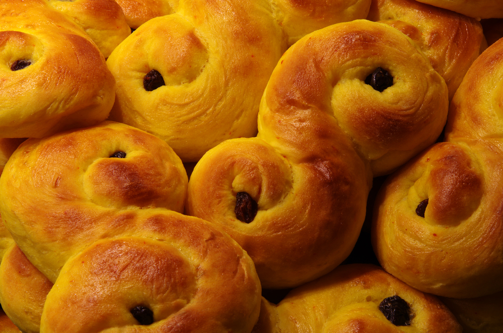 Närbild på flera lussekatter, saffransbullar med russin, staplade tillsammans.