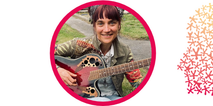 Kvinna med gitarr sitter utomhus på gräs och ler mot kameran, inramad av en rosa cirkel.
