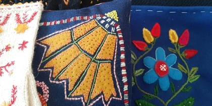 Närbild av färgglada broderade textilier med blommönster i olika färger och stilar.