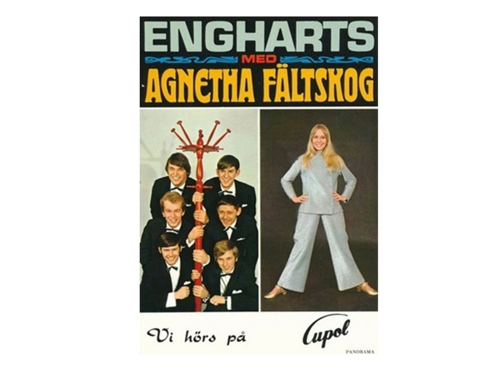 Affisch med texten 'Engharts med Agnetha Fältskog', visar en musikgrupp och en kvinna i ljus kostym.